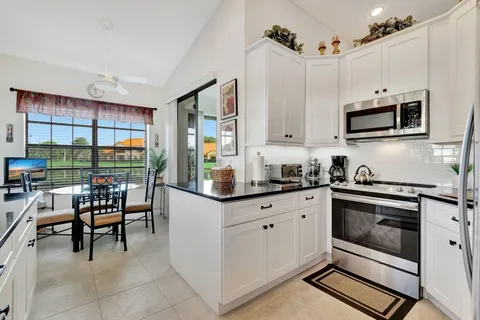 a kitchen with granite countertop white cabinets and sink