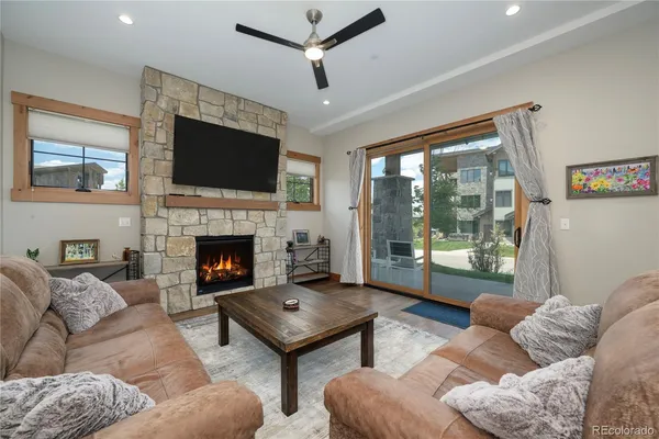 a living room with furniture a flat screen tv and a fireplace