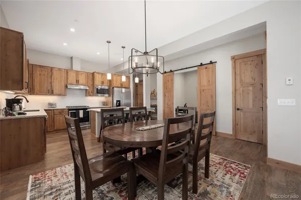 a dining room with stainless steel appliances kitchen island granite countertop a dining table chairs and view living room