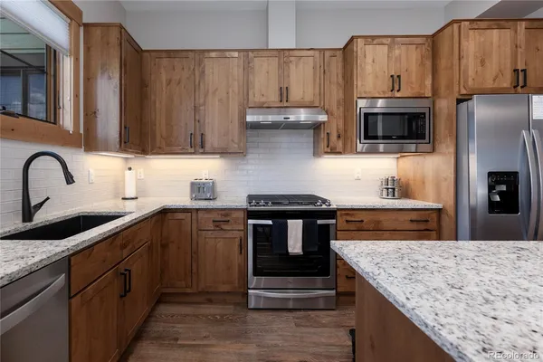 a kitchen with a stove sink and cabinets