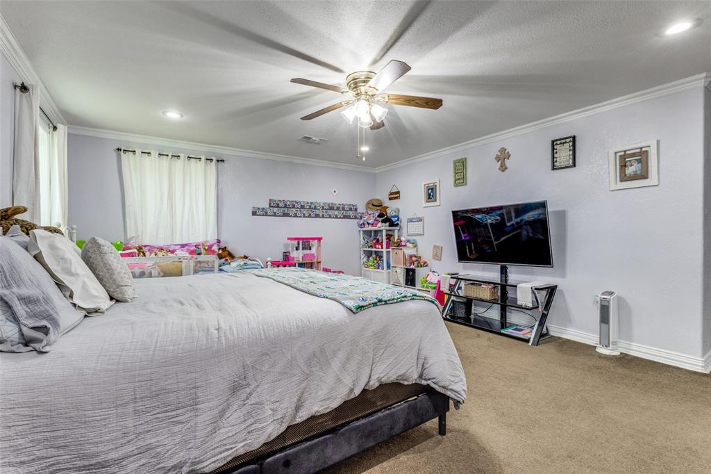 1590 Farm Road 2352 Sumner, TX 75486 - Photo 19 of 40 a bedroom with a bed and a flat screen tv