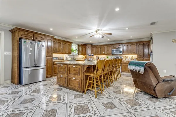 a living room with stainless steel appliances furniture a dining table and kitchen view