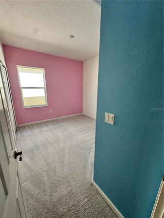 an empty room with windows and ceiling fan