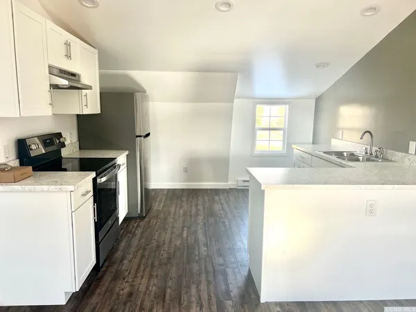a kitchen with granite countertop a sink a counter space and cabinets
