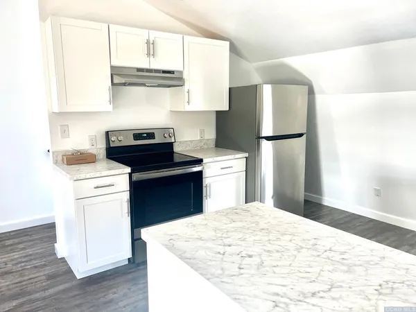 a kitchen with a refrigerator sink and cabinets