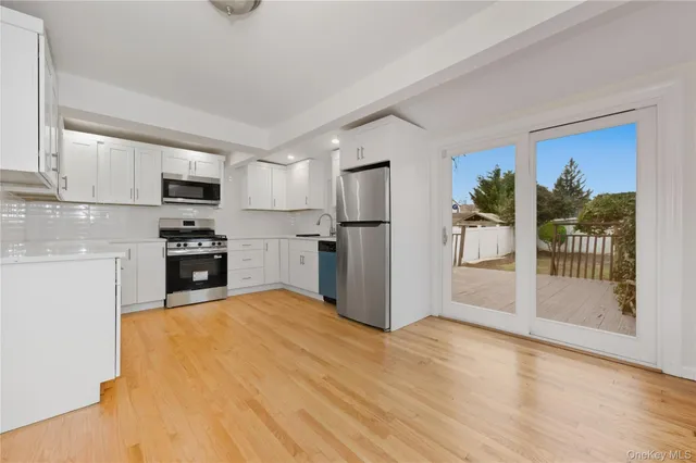 a kitchen with granite countertop a refrigerator and a stove top oven