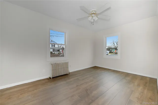 an empty room with a window and a ceiling fan