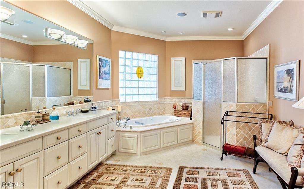 2729 Wulfert Road Sanibel, FL 33957 - Photo 16 of 31 a bathroom with double vanity sink a mirror a bathtub and next to a window
