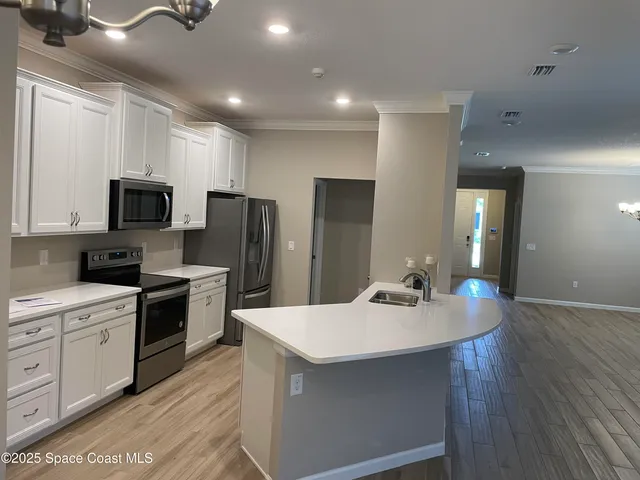 a kitchen with kitchen island a sink stainless steel appliances and cabinets