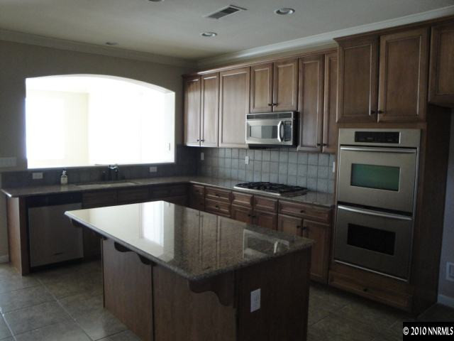 11335 Torino Way Reno, NV 89521 - Photo 2 of 9 a kitchen with kitchen island granite countertop a sink stove and microwave