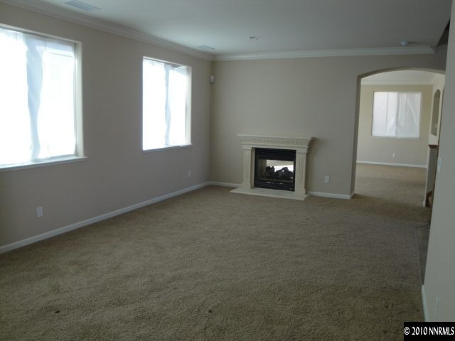 11335 Torino Way Reno, NV 89521 - Photo 4 of 9 an empty room with windows and fireplace
