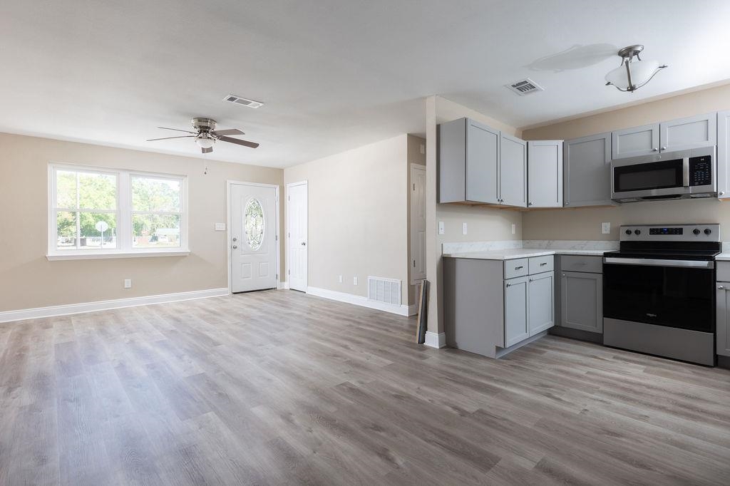 3941 Baybrook Drive Pace, FL 32571 - Photo 4 of 28 a view of kitchen with granite countertop a stove top oven a sink dishwasher and a refrigerator with wooden floor