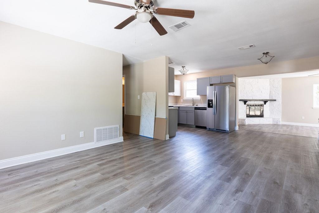 3941 Baybrook Drive Pace, FL 32571 - Photo 5 of 28 a view of a electric appliances in kitchen and empty room with wooden floor