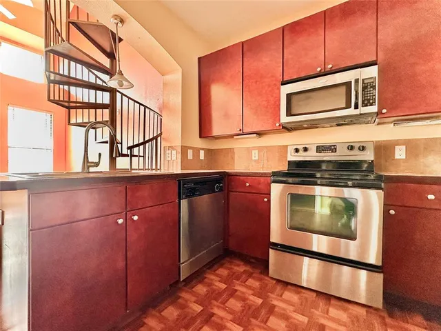a kitchen with stainless steel appliances granite countertop a stove microwave and cabinets