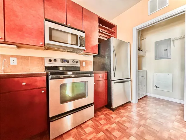 a kitchen with granite countertop a refrigerator and a stove