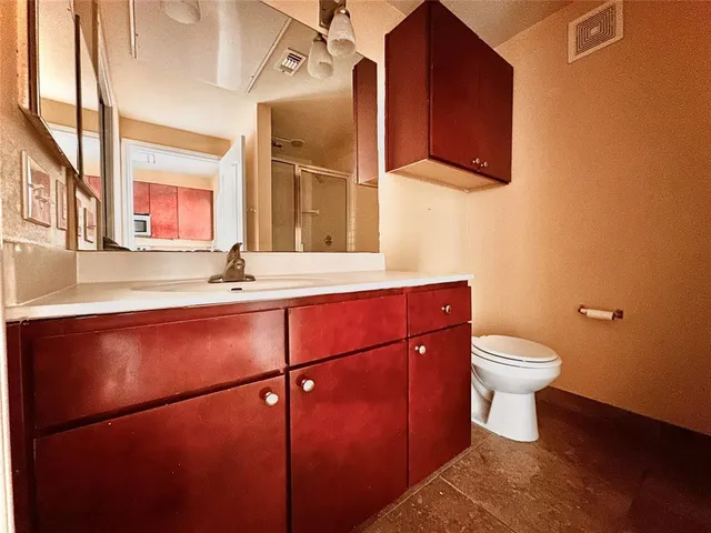 a bathroom with a toilet a sink and mirror