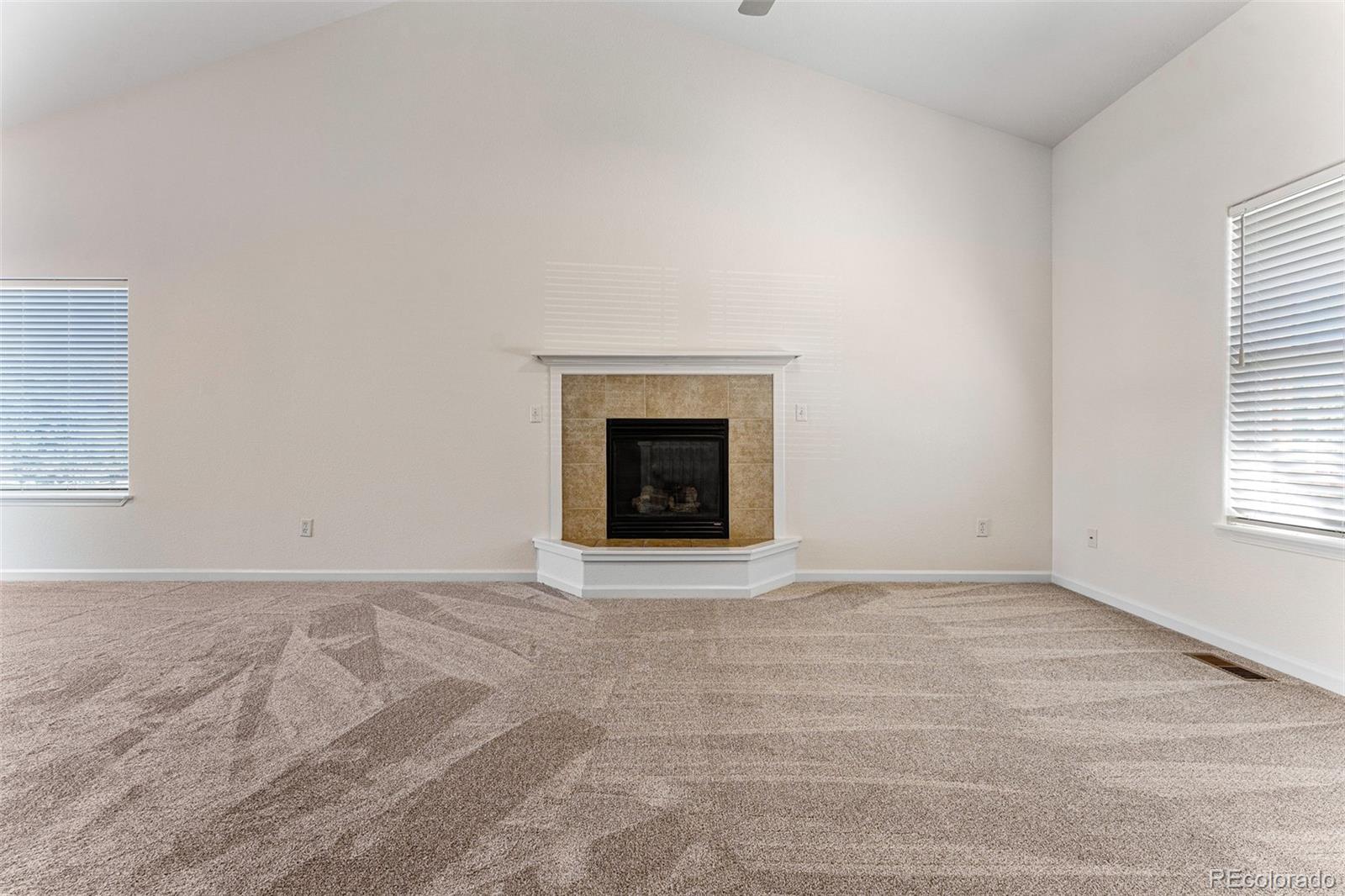 400 Sorrel Drive Windsor, CO 80550 - Photo 11 of 37 an empty room with windows and fireplace
