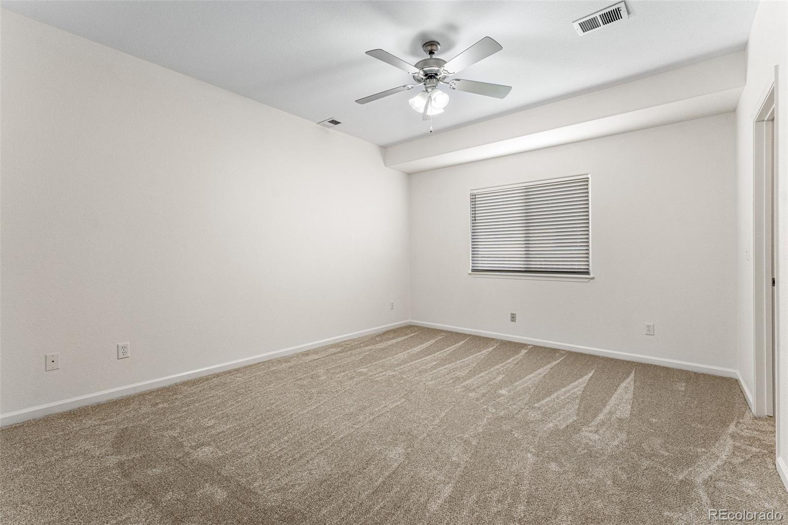 400 Sorrel Drive Windsor, CO 80550 - Photo 15 of 37 an empty room with a chandelier fan and windows