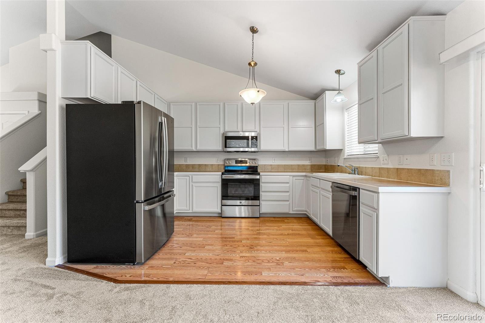 400 Sorrel Drive Windsor, CO 80550 - Photo 3 of 37 a kitchen with granite countertop a refrigerator oven a sink and dishwasher