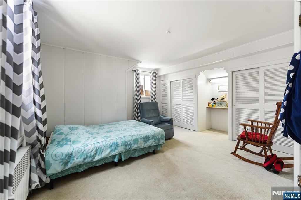 722 Oak Street Ridgefield, NJ 07657 - Photo 9 of 17 a bedroom with a bed and a chandelier