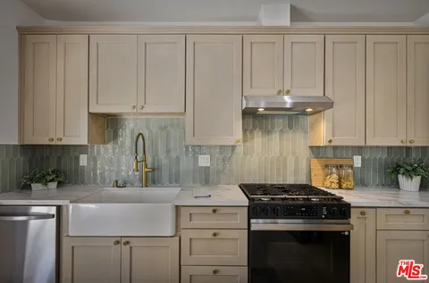 a kitchen with a stove and white cabinets
