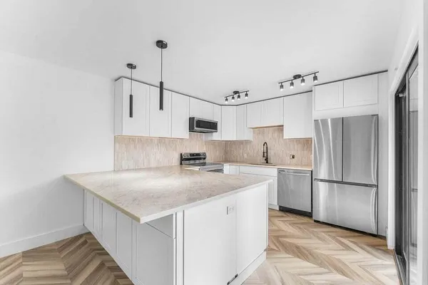 a kitchen that has a cabinets a sink and a refrigerator