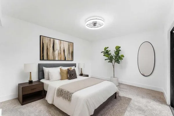 a bedroom with a bed and painting on the wall