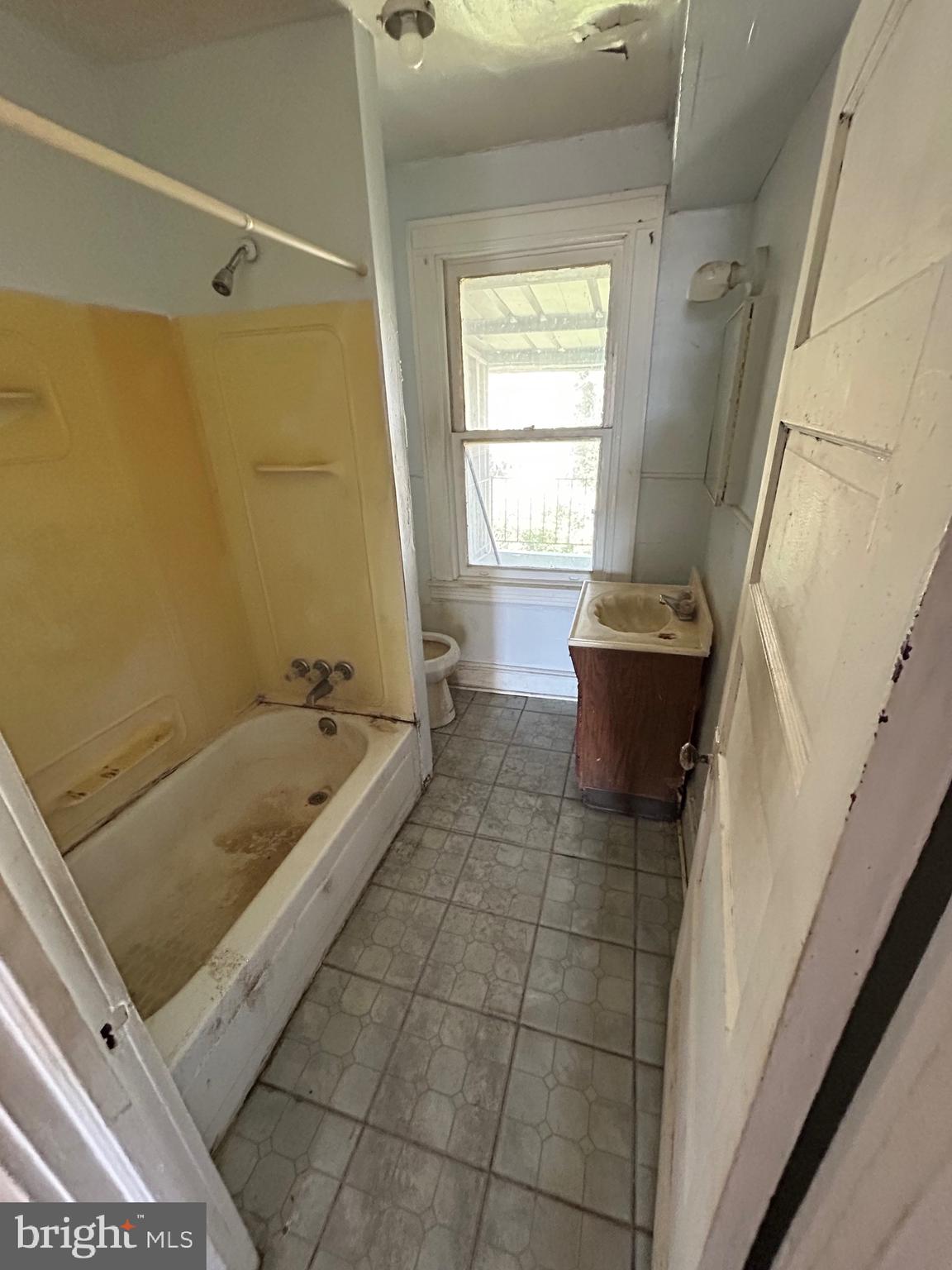3206 Hayward Avenue Baltimore, MD 21215 - Photo 12 of 12 a bathroom with a tub a sink and a window