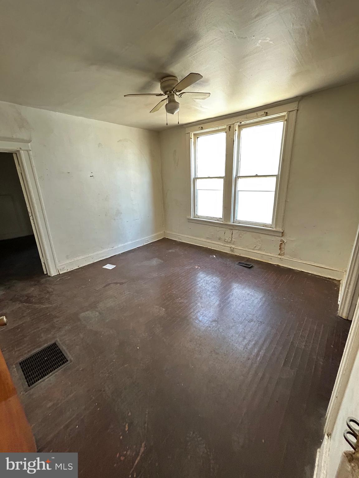 3206 Hayward Avenue Baltimore, MD 21215 - Photo 2 of 12 an empty room with wooden floor and windows