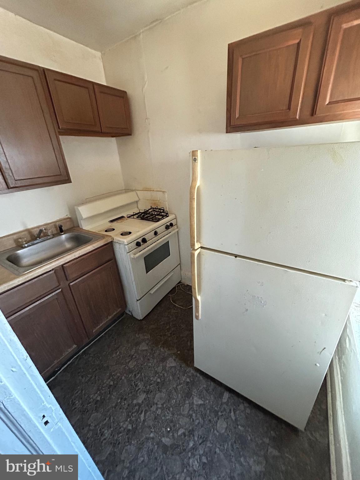 3206 Hayward Avenue Baltimore, MD 21215 - Photo 5 of 12 a kitchen with a refrigerator a stove a microwave and cabinets