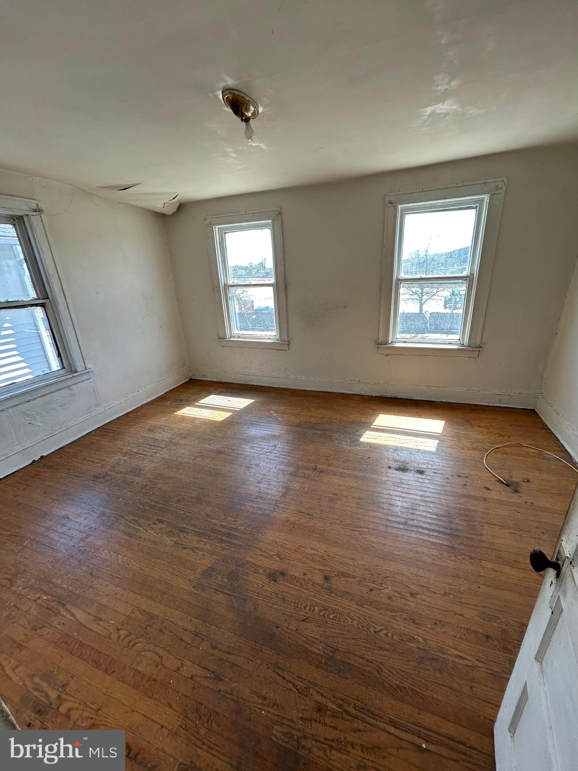 3206 Hayward Avenue Baltimore, MD 21215 - Photo 7 of 12 an empty room with wooden floor and windows