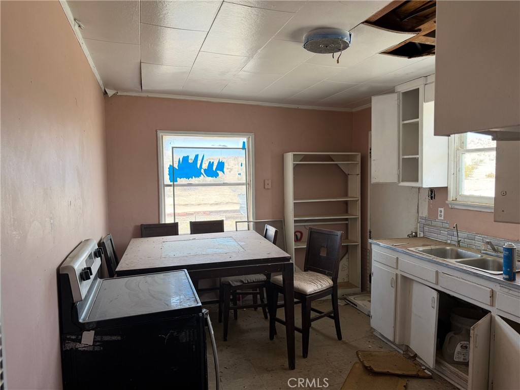 6316 Isleta Road Twentynine Palms, CA 92277 - Photo 3 of 13 a room with a table chairs and a refrigerator