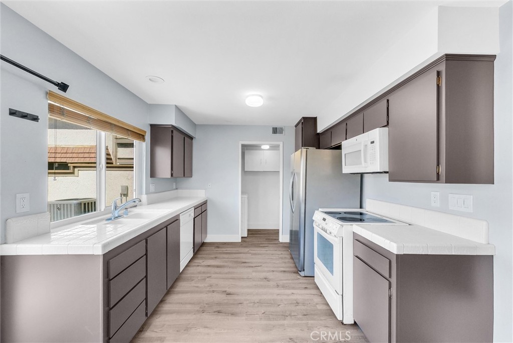 13966 Hammon Place Westminster, CA 92683 - Photo 13 of 45 a large kitchen with stainless steel appliances a sink and a refrigerator