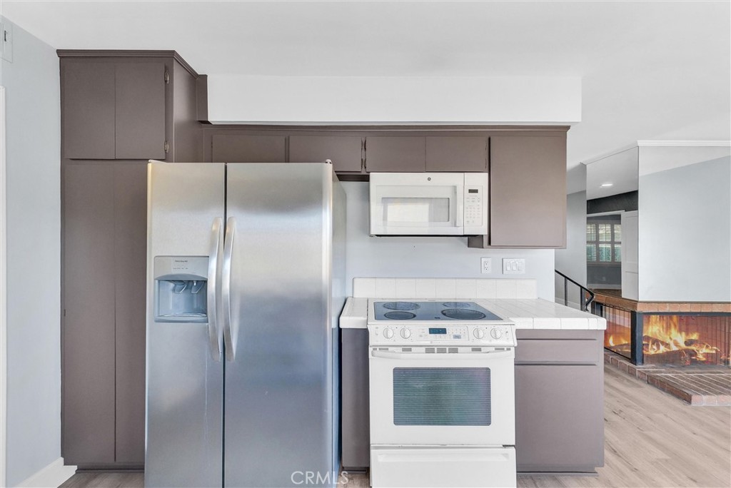 13966 Hammon Place Westminster, CA 92683 - Photo 14 of 45 a kitchen with a refrigerator sink stove and cabinets