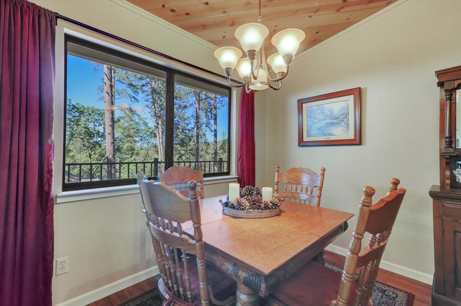17682 Alexandra Way Grass Valley, CA 95949 - Photo 19 of 55 a view of a dining room with furniture a chandelier and large windows