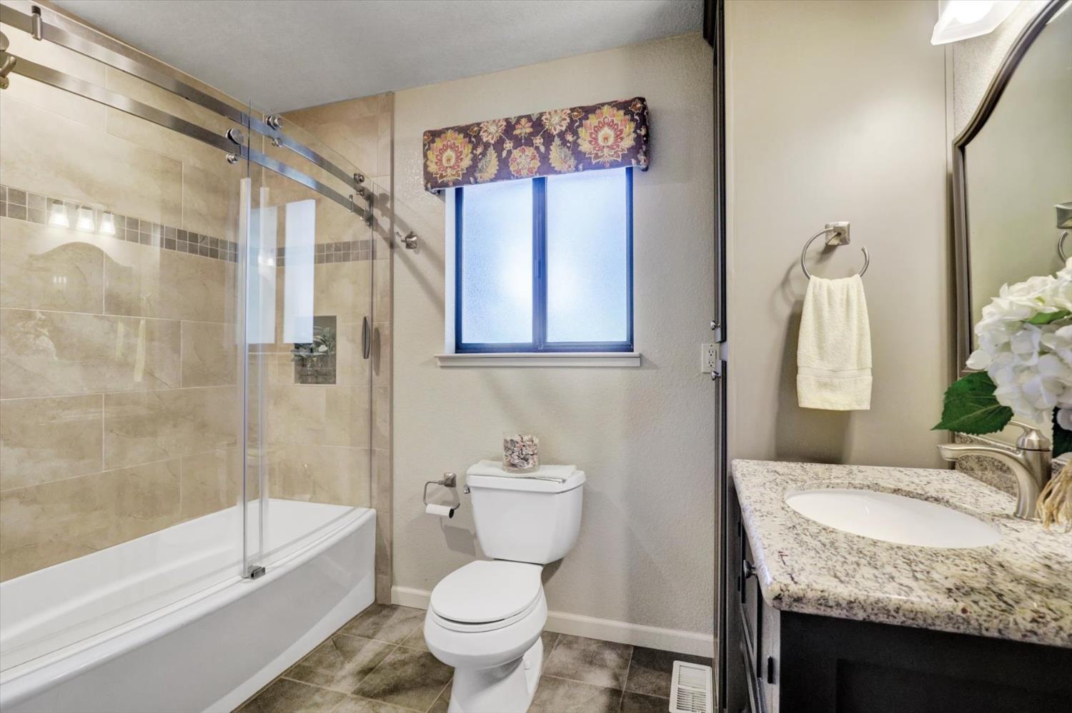 17682 Alexandra Way Grass Valley, CA 95949 - Photo 28 of 55 a bathroom with a granite countertop sink toilet and shower