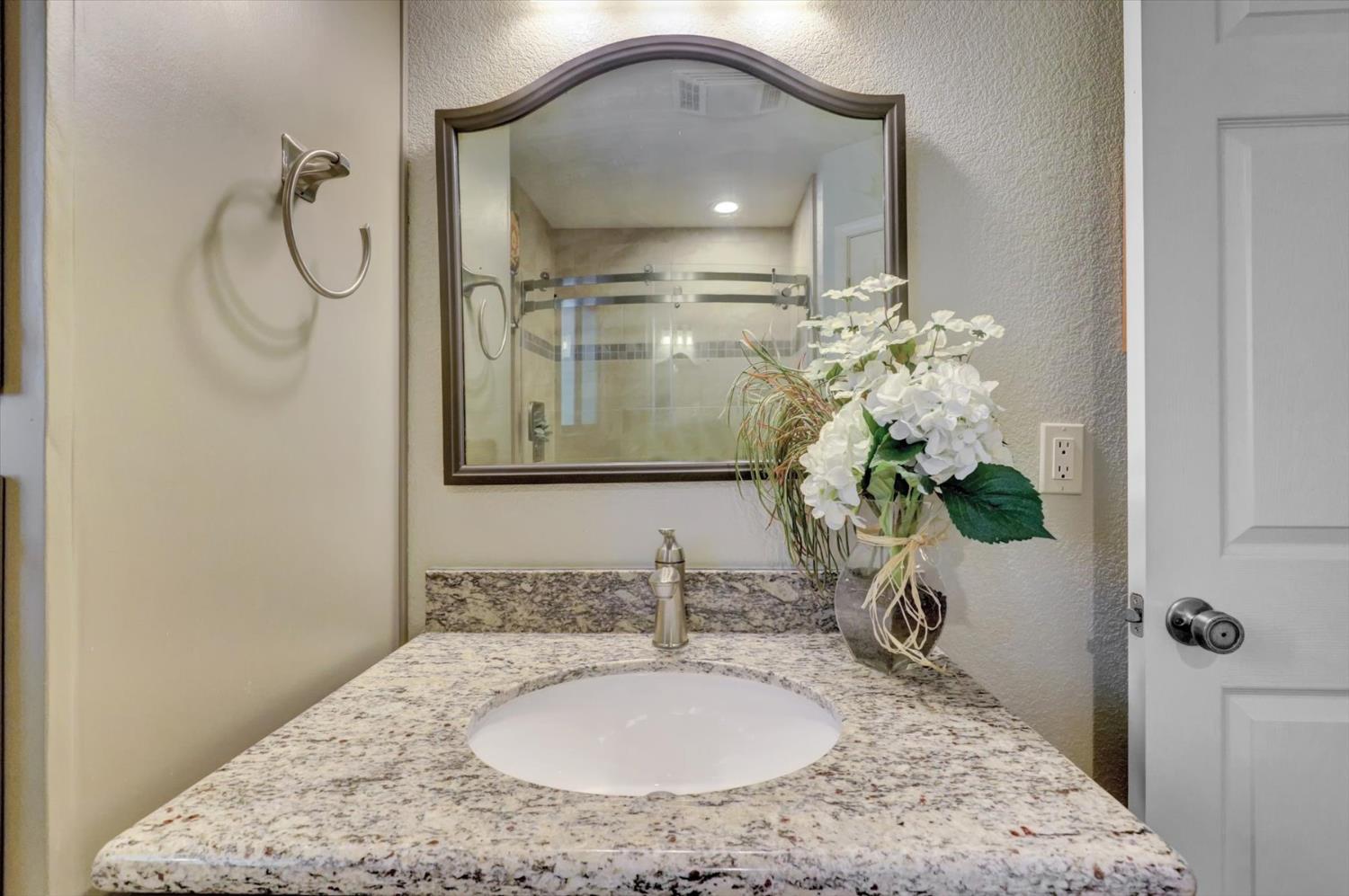 17682 Alexandra Way Grass Valley, CA 95949 - Photo 29 of 55 a bathroom with a granite countertop sink a mirror and a shower