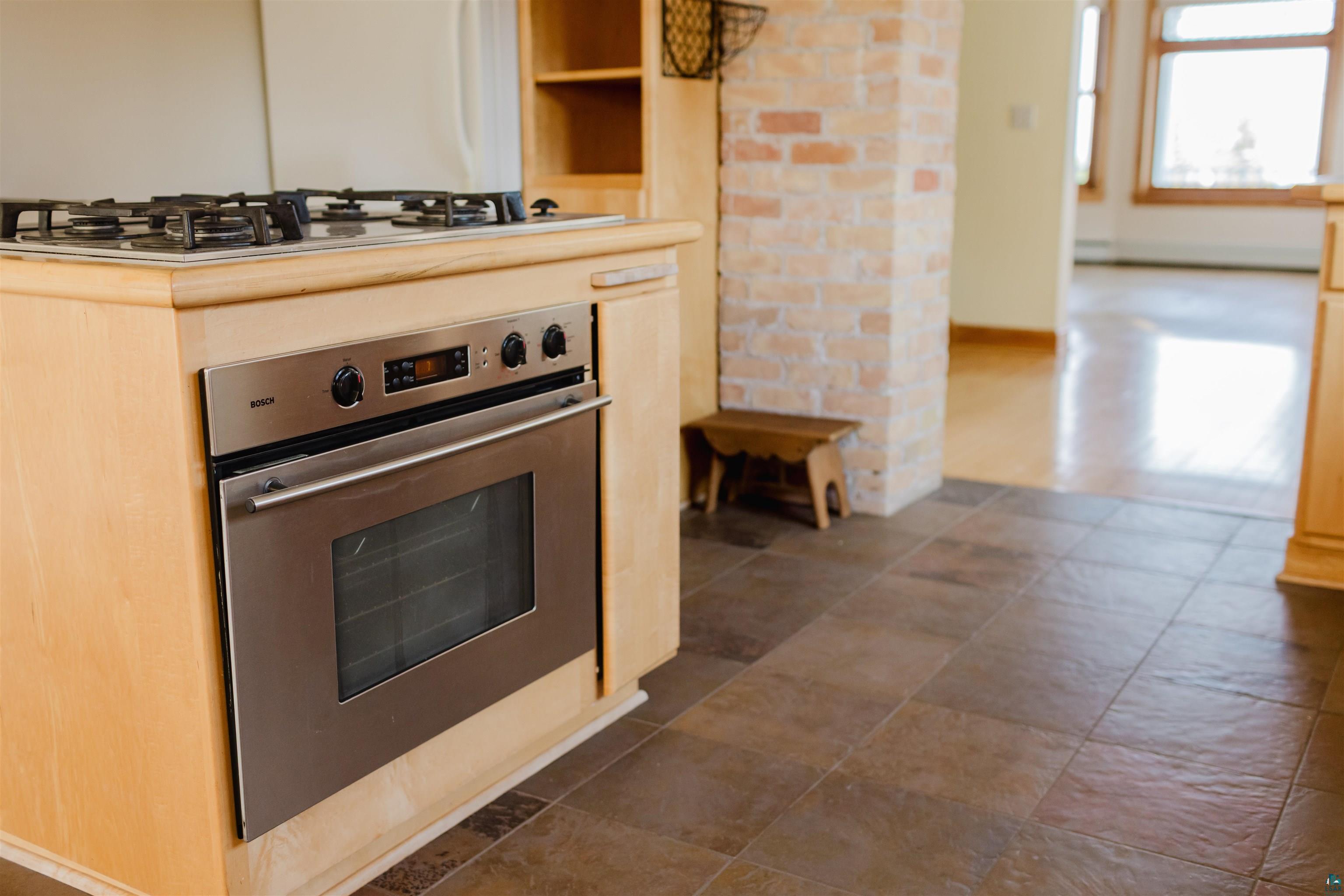 13 West 8th Street Duluth, MN 55806 - Photo 11 of 57 Built-in stainless steel oven and gas cooktop integrated into wood cabinetry
