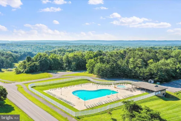 a view of a swimming pool with a lawn chairs and floor to ceiling window