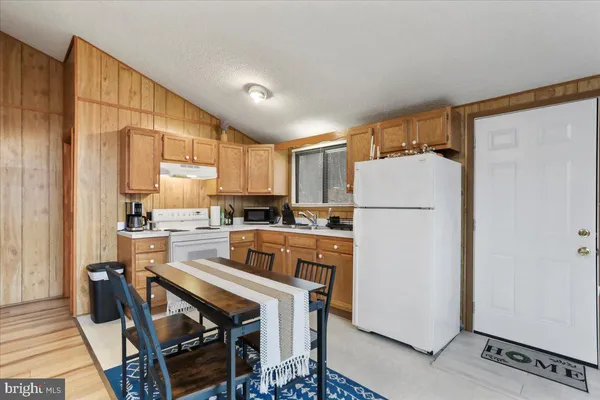 a kitchen with a refrigerator a stove top oven a sink and cabinets