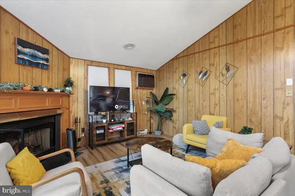 a living room with furniture a fireplace and a flat screen tv