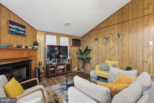 a living room with furniture a fireplace and a flat screen tv