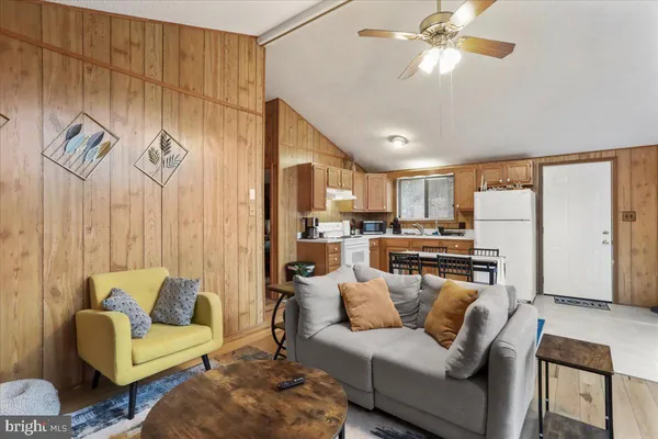 a living room with furniture and a view of kitchen