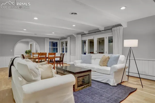 a living room with furniture and a wooden floor