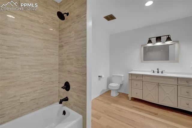 a bathroom with a tub sink toilet and mirror