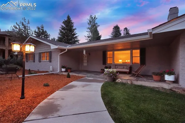 a backyard of a house with table and chairs a fire pit and two lawn chairs