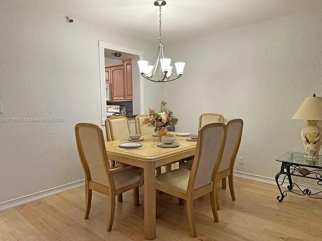 a dining room with furniture a chandelier and wooden floor