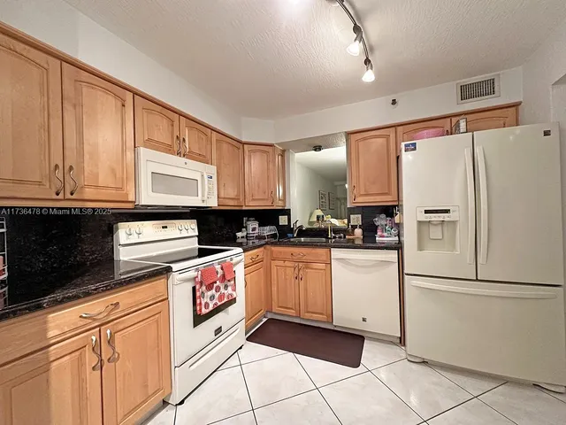 a kitchen with stainless steel appliances granite countertop a refrigerator sink and cabinets