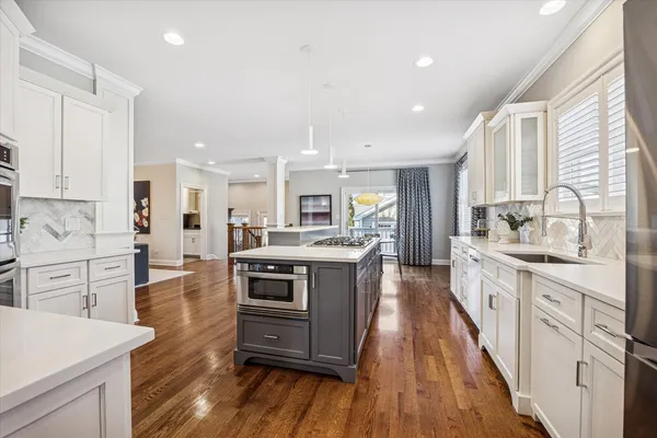 a large kitchen with cabinets wooden floor and stainless steel appliances