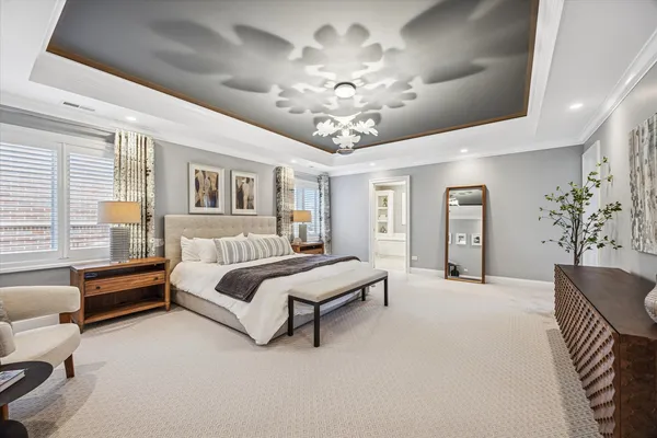 a spacious bedroom with a bed and chandelier